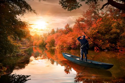 A man in a boat on the river in the autumn