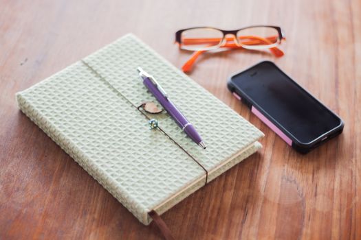 Notebook and pen on wooden table, stock photo