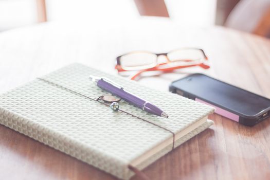 Notebook and smartphone on wooden table, stock photo