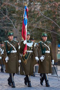 Members of the Carabineros marching with a ceremonial flag as part of the changing of the guard ceremony at La Moneda in Santiago, Chile