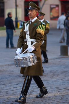 Member of the Carabineros Band marching and playing the drum as part of the changing of the guard ceremony at La Moneda in Santiago, Chile