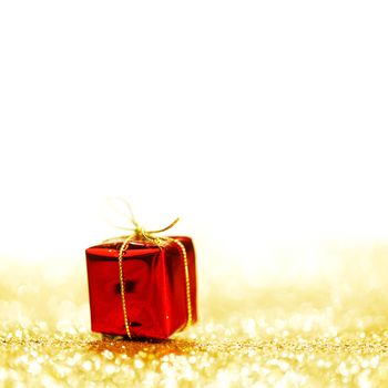 Decorative red box with holiday gift on shiny glitter background