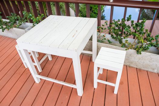 white wooden table and chairs set on balcony