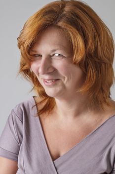 Red hair woman in her forties give a cute expression to the camera