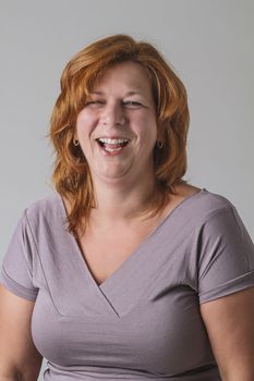 Red hair woman in her forties laughing out loud