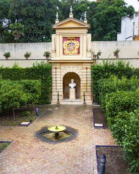 Statues Fountain Royal Symbol Garden Alcazar Royal Palace Seville Andalusia Spain.  Originally a Moorish Fort, oldest Royal Palace still in use in Europe. Built in the 1100s and rebuilt in the 1300s. 