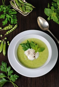 Portion cream soup with green peas with mint cream

