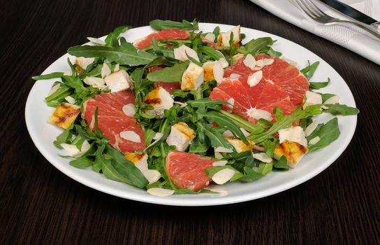 Salad with grilled chicken and arugula, grapefruit, almonds
