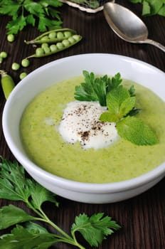 Portion cream soup with green peas with mint cream

