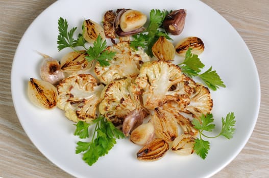 Warm appetizer of fried pieces of cauliflower with garlic and onion
