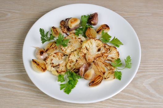 Warm appetizer of fried pieces of cauliflower with garlic and onion
