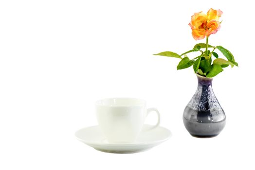 white cup and rose in a black vase