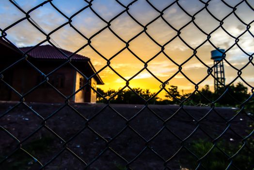 the beautiful fence mesh background with the blure sunset.