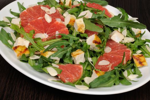 Salad with grilled chicken and arugula, grapefruit, almonds