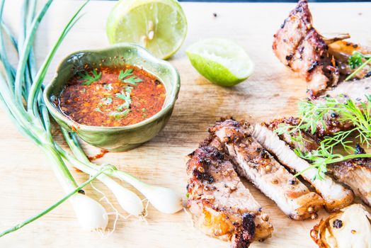 Sliced roasted pork with spices on wooden board