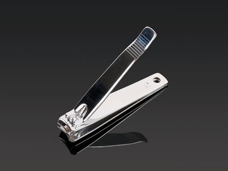 nail clippers with reflection on grey background