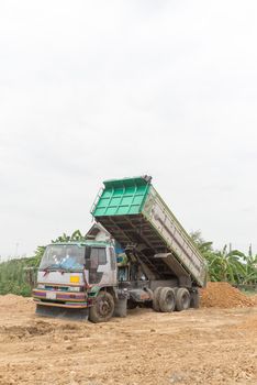 Dump truck dumps its load of rock and soil on land thailand