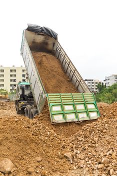 Dump truck dumps its load of rock and soil on land thailand