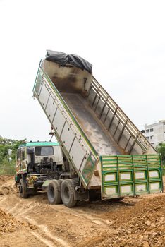 Dump truck dumps its load of rock and soil on land thailand
