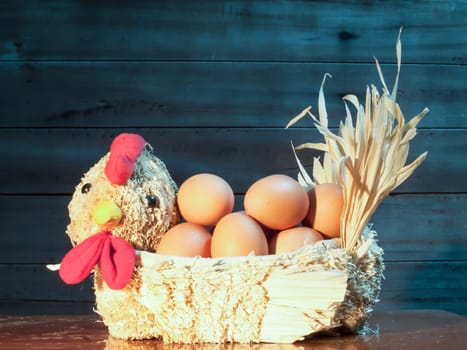 Still light eggs in straw hens on wood and old wood background.