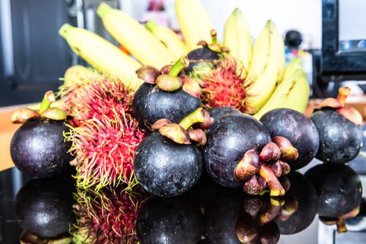 Selection Of Tropical Fruits on black glass background.