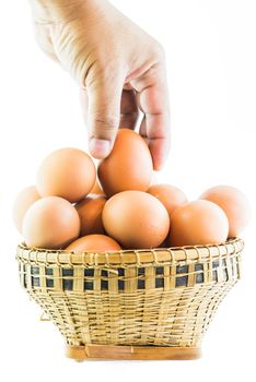 Brown eggs in the basket on white.