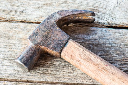 Hammer on a old wooden table top. Industrial tool.