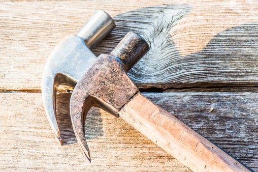 Hammer on a old wooden table top. Industrial tool.