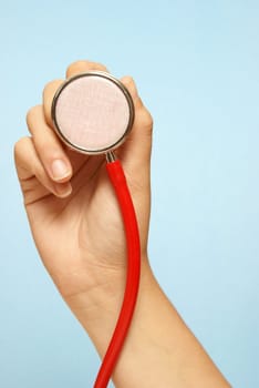 A medical professional holding a stethoscope to check the patient.