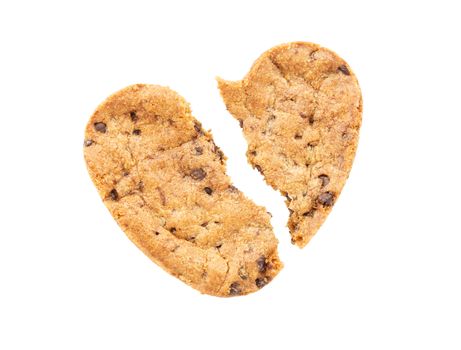 Cracked heart shaped chocolate chip cookie isolated on white background