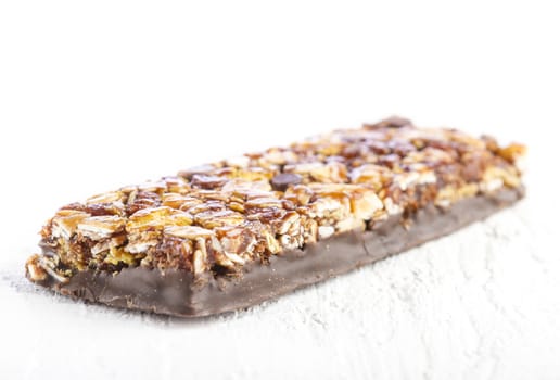 Chocolate Muesli Bar on white wooden background