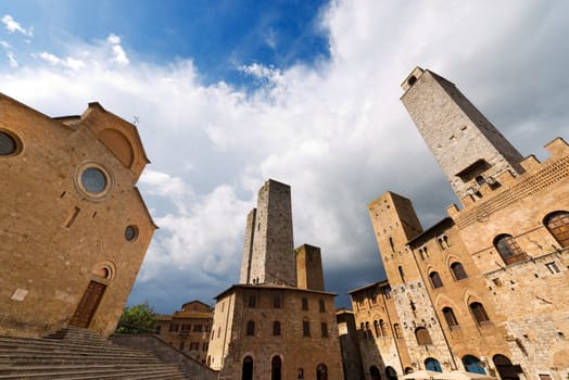 Buildings and towers in Piazza del Duomo, San Gimignano medieval town (UNESCO heritage), Siena, Tuscany, Italy