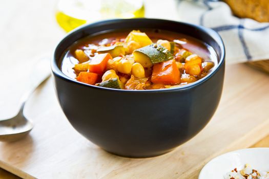 Vegetables soup with chickpea by bread loaf