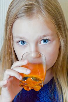 Cute girl with blond long hair drinking beverage