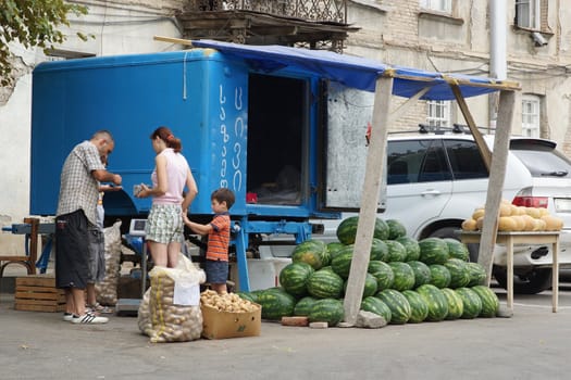 TBILISI, GEORGIA - JUNE 29, 2014: Man selling melons on a fruit stand on June 29, 2014 in Tbilisi, Georgia, East Europe
