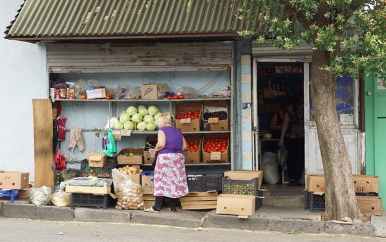 TBILISI, GEORGIA - JUNE 29, 2014: Woman selling vegetables at a typic convenience store on June 29, 2014 in Tbilisi, Georgia, East Europe