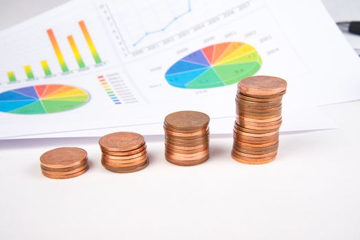 British pound sterling coins and notes with financial chart in background