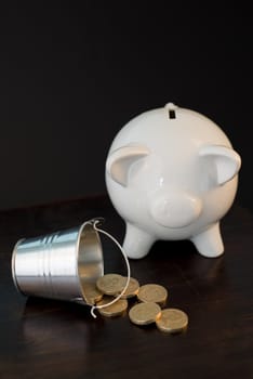 white piggy bank isolated on black background with coins