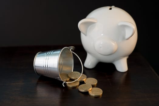 white piggy bank isolated on black background with coins