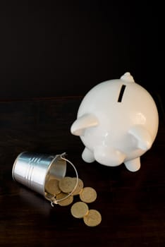 white piggy bank isolated on black background with coins