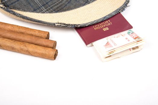 Cuban cigars and hat with passport and cuban currency pesos  on white isolated background