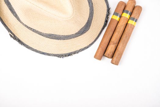 Cuban cigars and straw hat on white isolated background