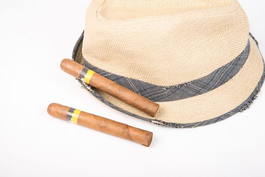 Cuban cigars and hat on white isolated background