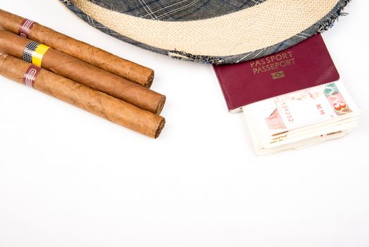 Cuban cigars and hat with passport and cuban currency pesos  on white isolated background