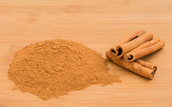 Cinnamon  whole and ground on a bamboo chopping board 
