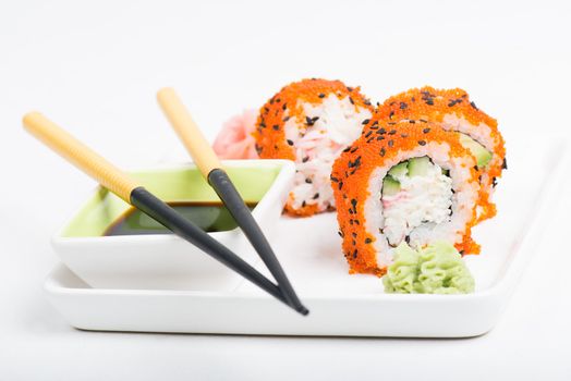 Chopsticks and sushi on the plate, light background