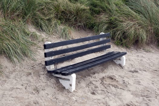 bench covered in sand from the winter storms in Ireland