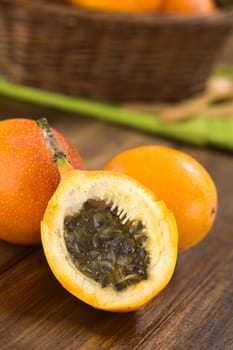 Sweet granadilla or grenadia (lat. Passiflora ligularis) fruit cut in half,  of which the seeds and the surrounding juicy pulp is eaten or is used to prepare juice  (Selective Focus, Focus on the front of the seeds)