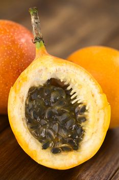 Sweet granadilla or grenadia (lat. Passiflora ligularis) fruit cut in half, of which the seeds and the surrounding juicy pulp is eaten or is used to prepare juice (Selective Focus, Focus on the front of the seeds)