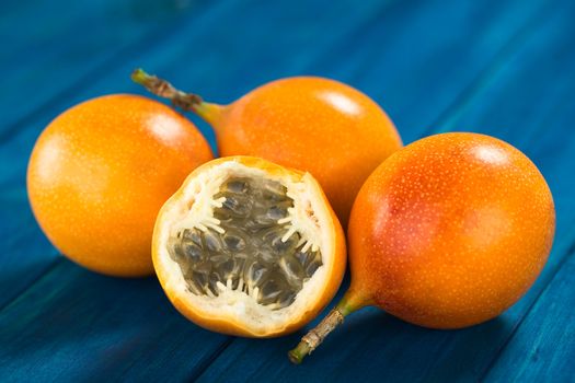 Sweet granadilla or grenadia (lat. Passiflora ligularis) fruit cut in half,  of which the seeds and the surrounding juicy pulp is eaten or is used to prepare juice (Selective Focus, Focus on the front of the seeds)